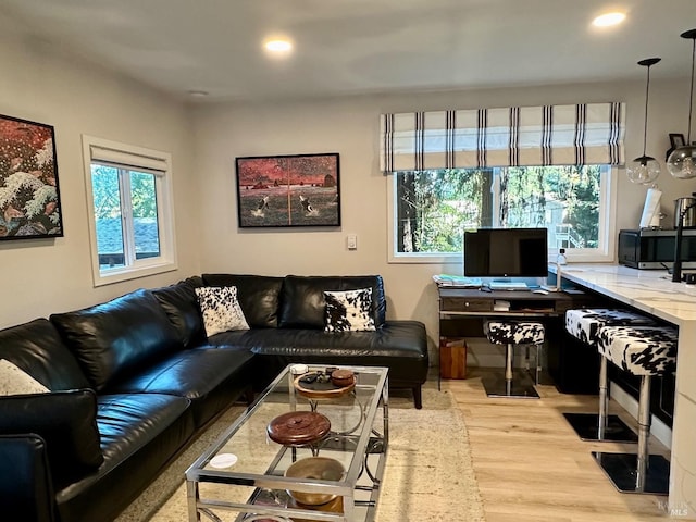 living area featuring a wealth of natural light, light wood-type flooring, and recessed lighting