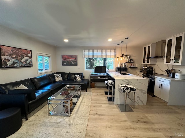 living area featuring plenty of natural light, recessed lighting, and light wood-type flooring