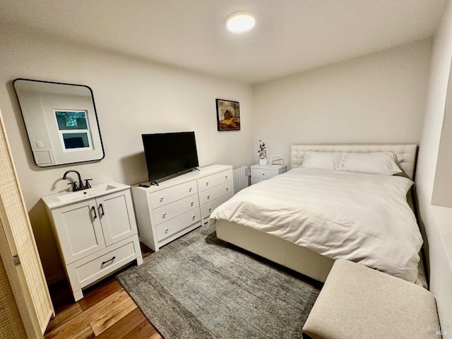 bedroom featuring dark wood-type flooring and a sink