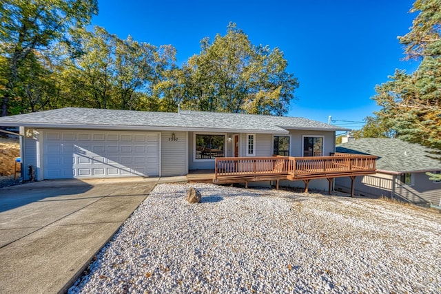 ranch-style house with a garage and a wooden deck