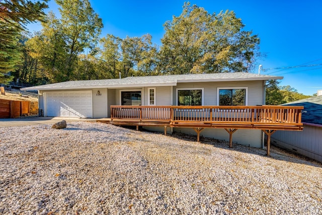 ranch-style house with a garage and a wooden deck