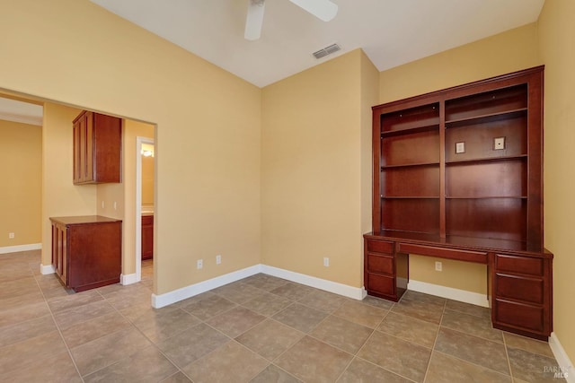 interior space with baseboards, ceiling fan, visible vents, and built in desk