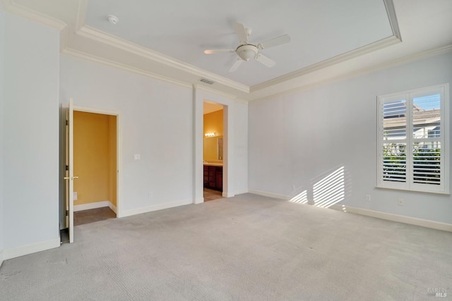carpeted spare room featuring visible vents, ornamental molding, baseboards, and a ceiling fan