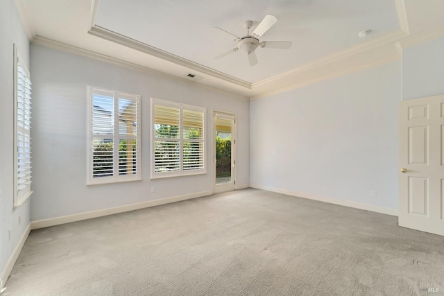 empty room featuring visible vents, baseboards, ornamental molding, a tray ceiling, and carpet flooring