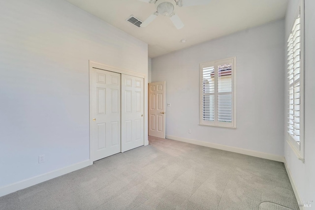 unfurnished bedroom with light carpet, baseboards, visible vents, and a closet