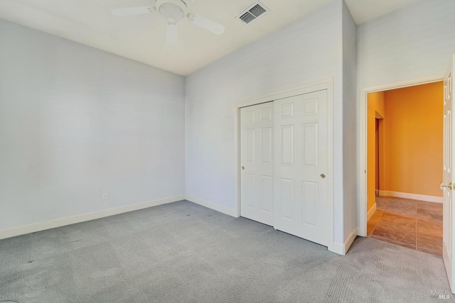 unfurnished bedroom with ceiling fan, carpet floors, visible vents, baseboards, and a closet