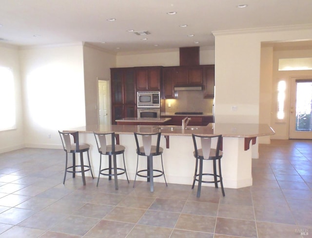 kitchen featuring crown molding, appliances with stainless steel finishes, light tile patterned floors, and backsplash