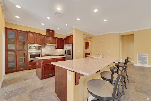 kitchen with stainless steel appliances, a large island, visible vents, and tasteful backsplash