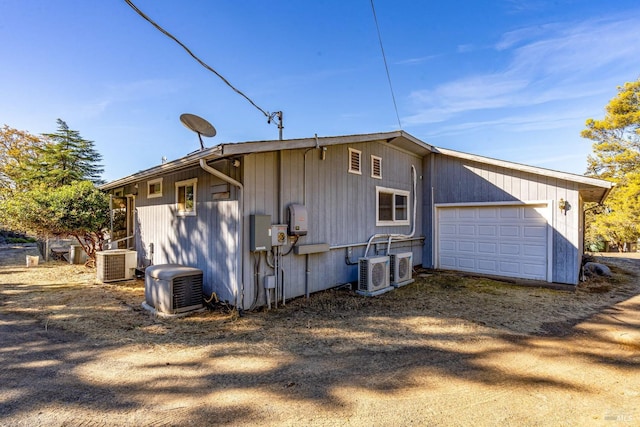 exterior space with central air condition unit and a garage