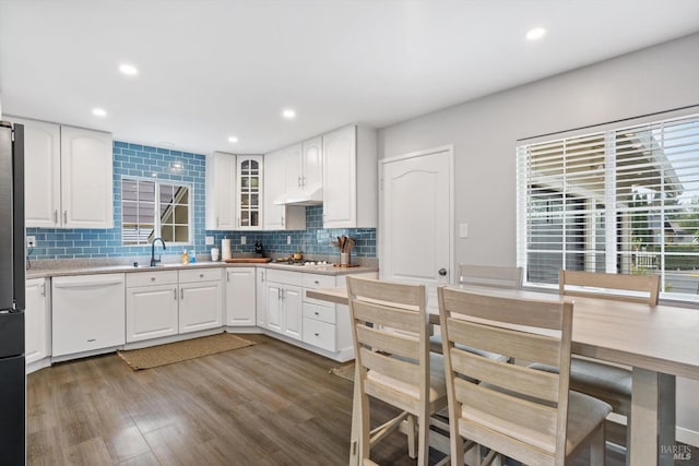 kitchen featuring hardwood / wood-style flooring, sink, appliances with stainless steel finishes, white cabinets, and decorative backsplash