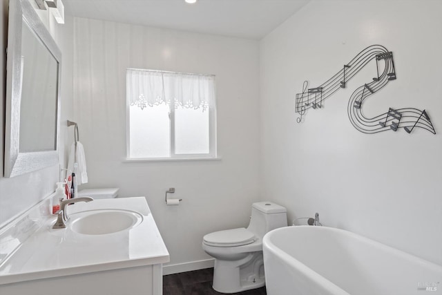 bathroom with toilet, a washtub, and vanity