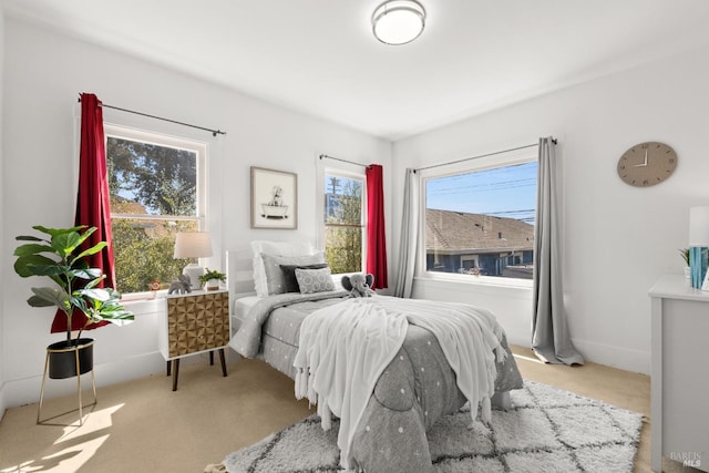 carpeted bedroom featuring multiple windows