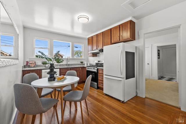 kitchen with white appliances and hardwood / wood-style flooring