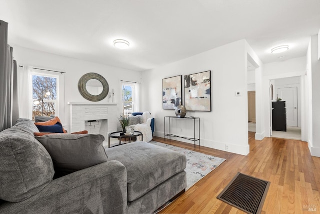 living room featuring hardwood / wood-style floors and a brick fireplace