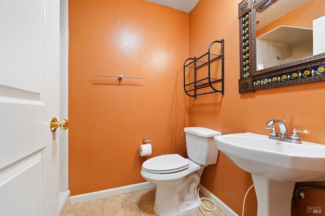 bathroom featuring toilet, sink, and tile patterned flooring