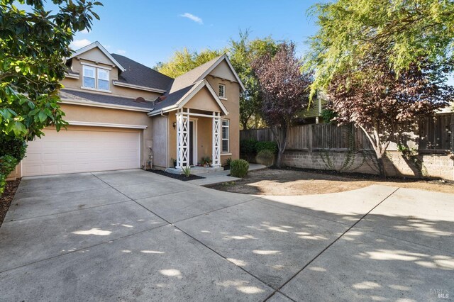 view of front facade featuring stucco siding, fence, concrete driveway, a garage, and a shingled roof