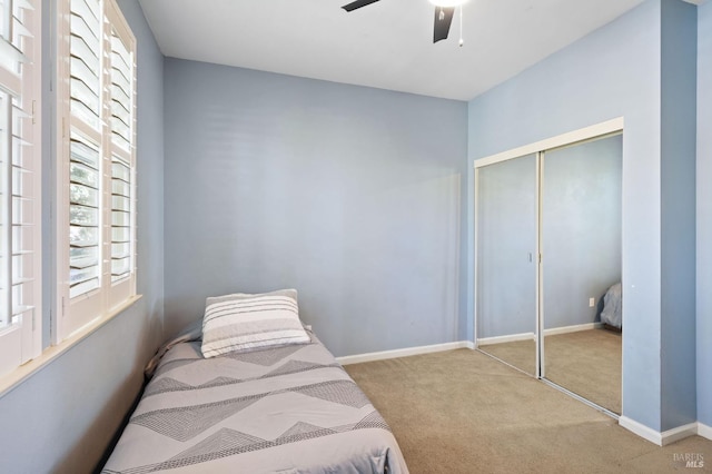 bedroom with ceiling fan, a closet, and light colored carpet