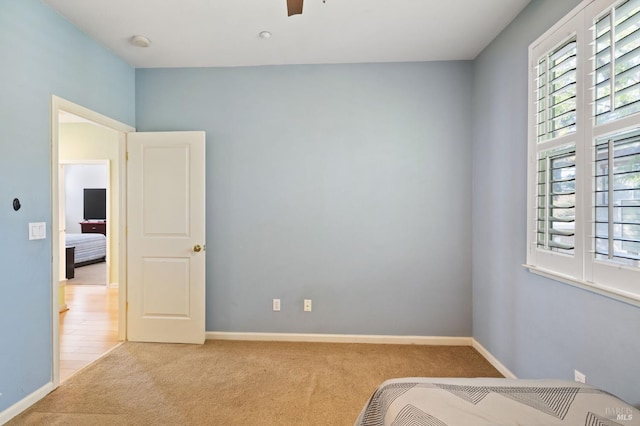 unfurnished bedroom with light colored carpet and ceiling fan