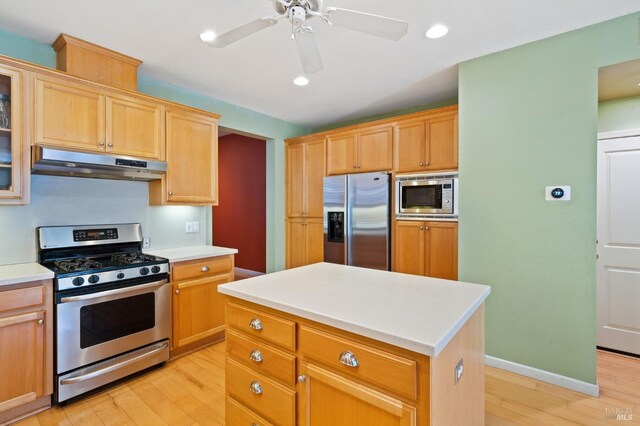 kitchen featuring stainless steel appliances, under cabinet range hood, light wood-style floors, light countertops, and recessed lighting