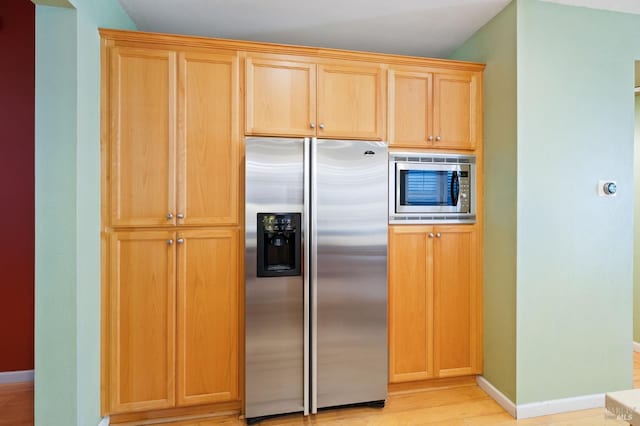 kitchen featuring appliances with stainless steel finishes, baseboards, light wood finished floors, and light brown cabinets