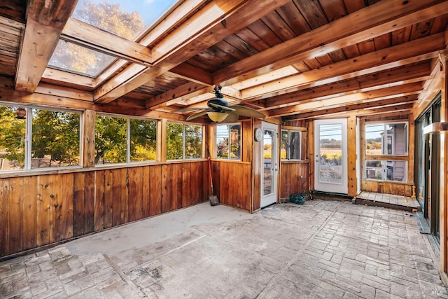 unfurnished sunroom featuring a wealth of natural light, ceiling fan, and a skylight