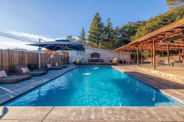 view of pool with a patio area and pool water feature