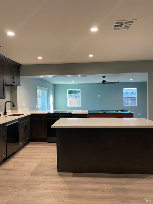 kitchen featuring a sink, light countertops, light wood-style flooring, recessed lighting, and visible vents