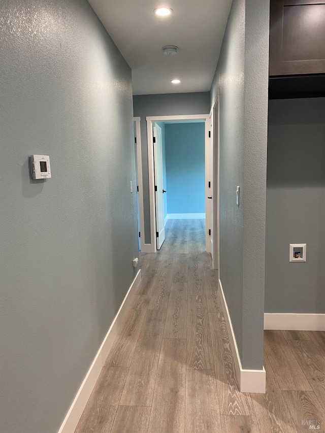 hallway featuring recessed lighting, baseboards, and light wood finished floors