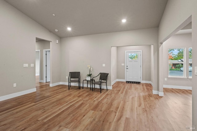 foyer entrance with light wood-type flooring and lofted ceiling