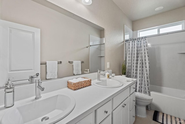 full bathroom featuring shower / tub combo with curtain, vanity, toilet, and a textured ceiling