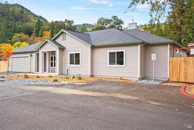 ranch-style home featuring a garage and a mountain view