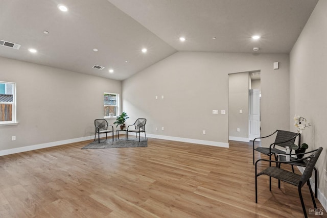 sitting room with light hardwood / wood-style floors and vaulted ceiling