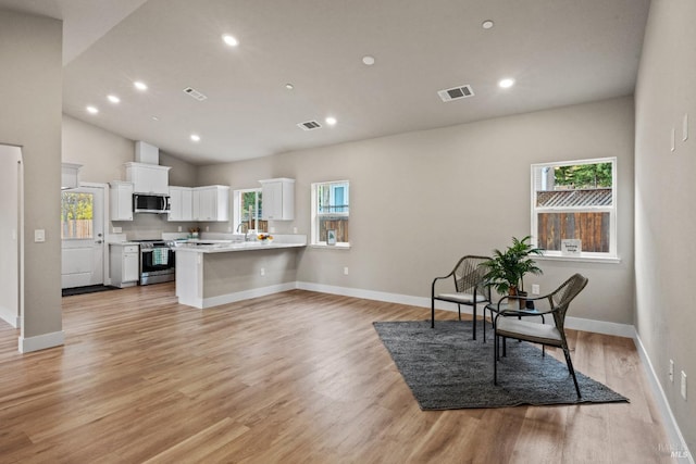 kitchen featuring plenty of natural light, kitchen peninsula, white cabinets, and stainless steel appliances