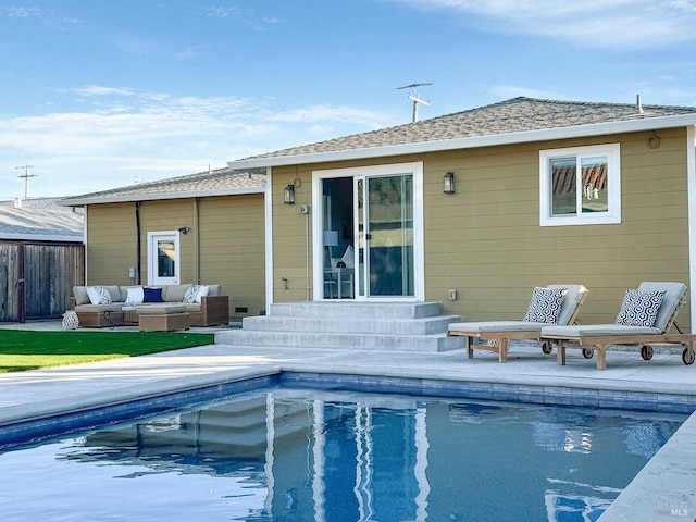 rear view of property featuring a fenced in pool, an outdoor hangout area, and a patio