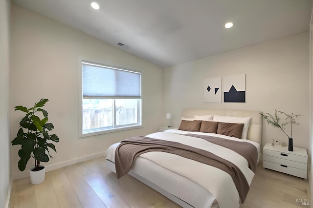 bedroom featuring light hardwood / wood-style floors and vaulted ceiling