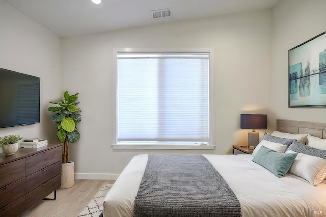 bedroom with multiple windows, light hardwood / wood-style flooring, and lofted ceiling