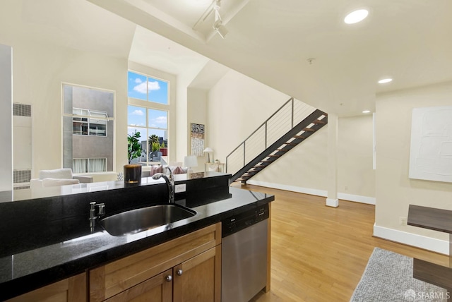 kitchen featuring light hardwood / wood-style flooring, stainless steel dishwasher, and sink