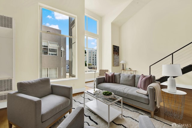 living room featuring a high ceiling and light hardwood / wood-style flooring