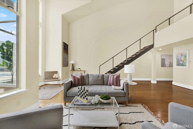 living room featuring wood-type flooring and a towering ceiling