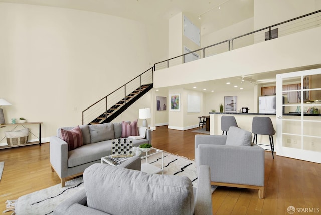 living room with a high ceiling and wood-type flooring