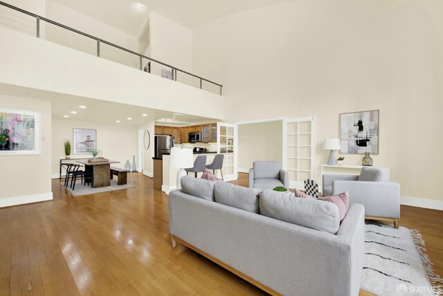 living room featuring light hardwood / wood-style floors and a high ceiling