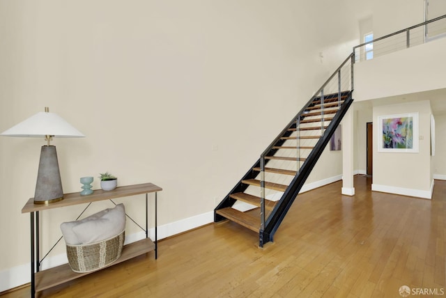 stairway featuring hardwood / wood-style floors and a towering ceiling