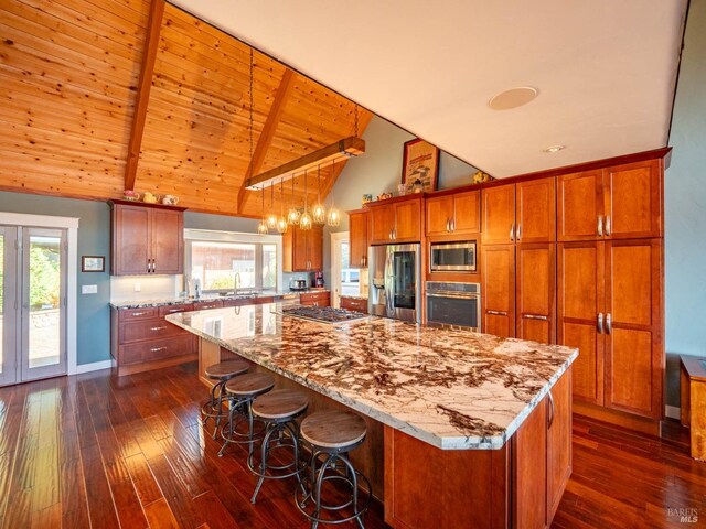 kitchen featuring a spacious island, stainless steel appliances, dark hardwood / wood-style floors, and beam ceiling