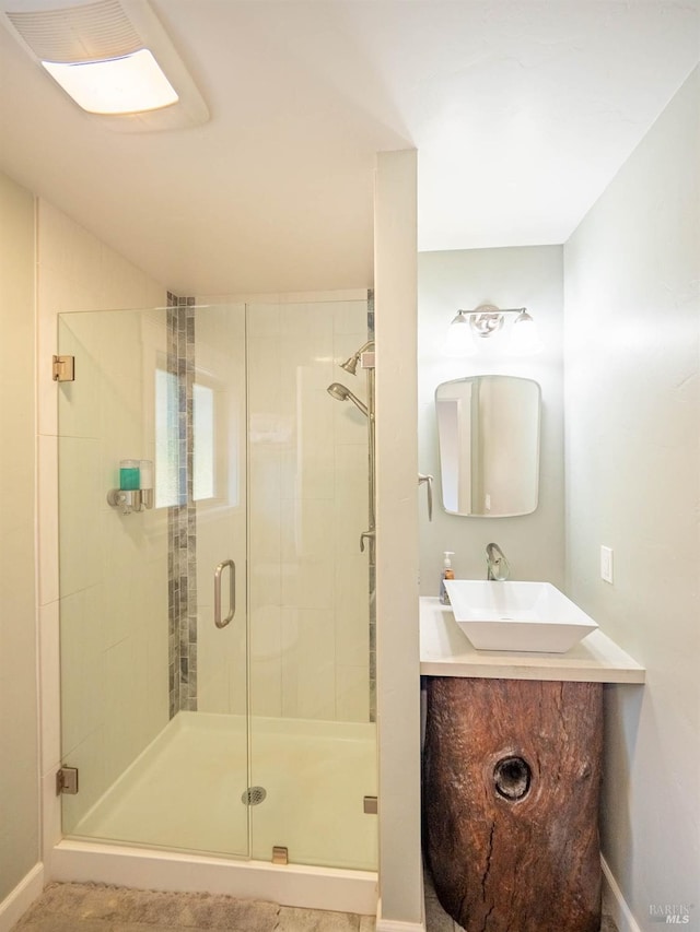 bathroom with a shower with door and vanity