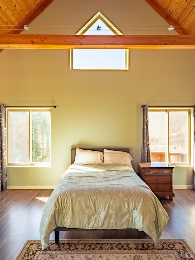 bedroom featuring dark hardwood / wood-style flooring, beamed ceiling, and multiple windows