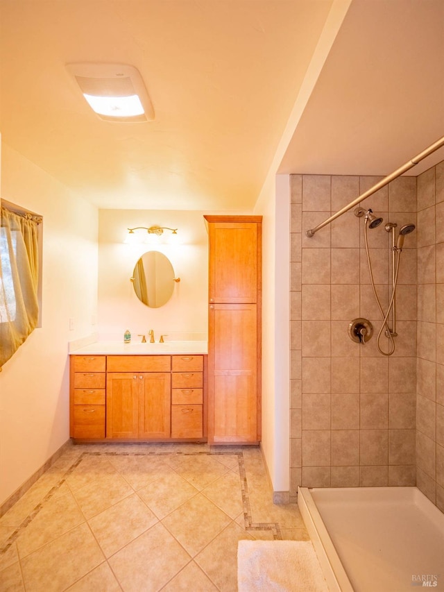 bathroom featuring tiled shower, vanity, and tile patterned floors