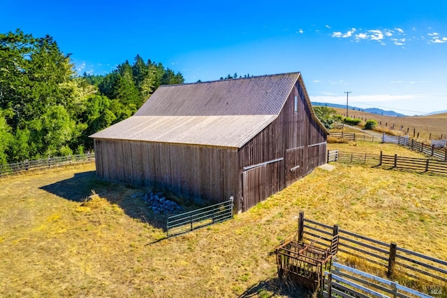 view of outbuilding featuring a rural view and a mountain view