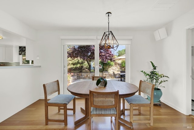 dining area with a chandelier and wood-type flooring