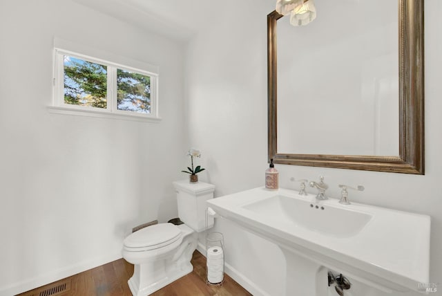 bathroom featuring toilet, sink, and hardwood / wood-style flooring