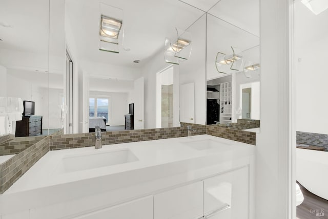 bathroom with hardwood / wood-style floors, vanity, and backsplash